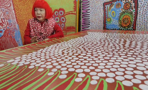In this photo taken Wednesday, Aug. 1, 2012, Japanese avant-garde artist Yayoi Kusama speaks during an interview at her studio, filled with wall-sized paintings throbbing with her repetitive dots, in Tokyo. Kusama's signature splash of dots has now arrived in the realm of fashion in a new collection from French luxury brand Louis Vuitton - bags, sunglasses, shoes and coats. The latest Kusama collection is showcased at its boutiques around the world, including New York, Paris, Tokyo and Singapore, sometimes with replica dolls of Kusama. (AP Photo/Itsuo Inouye)